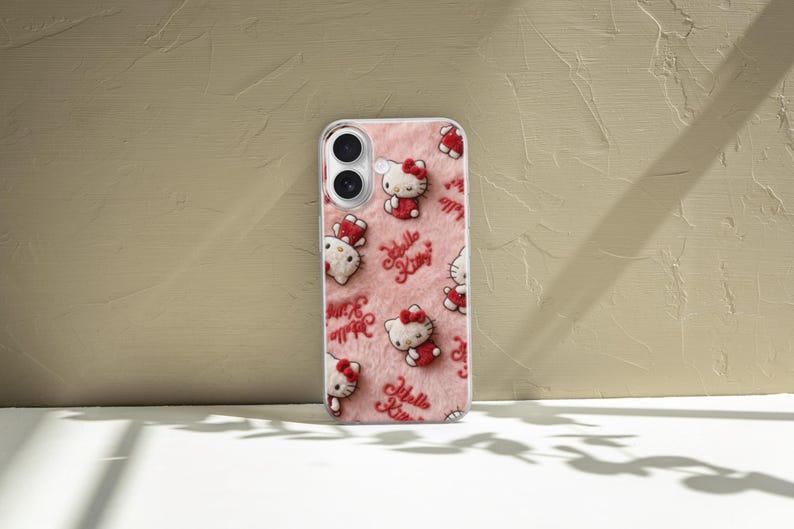 May include: A phone case featuring a repeating pattern of Hello Kitty characters in red and white on a pink, textured background. The words "Hello Kitty" are also printed in red. The case is made of clear plastic.
