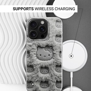 May include: A phone case with a gray, fuzzy texture and a repeating pattern of a cartoon cat face. The case is shown with a wireless charger. Text on the image reads: SUPPORTS WIRELESS CHARGING and SIDES ARE NOT PRINTED.