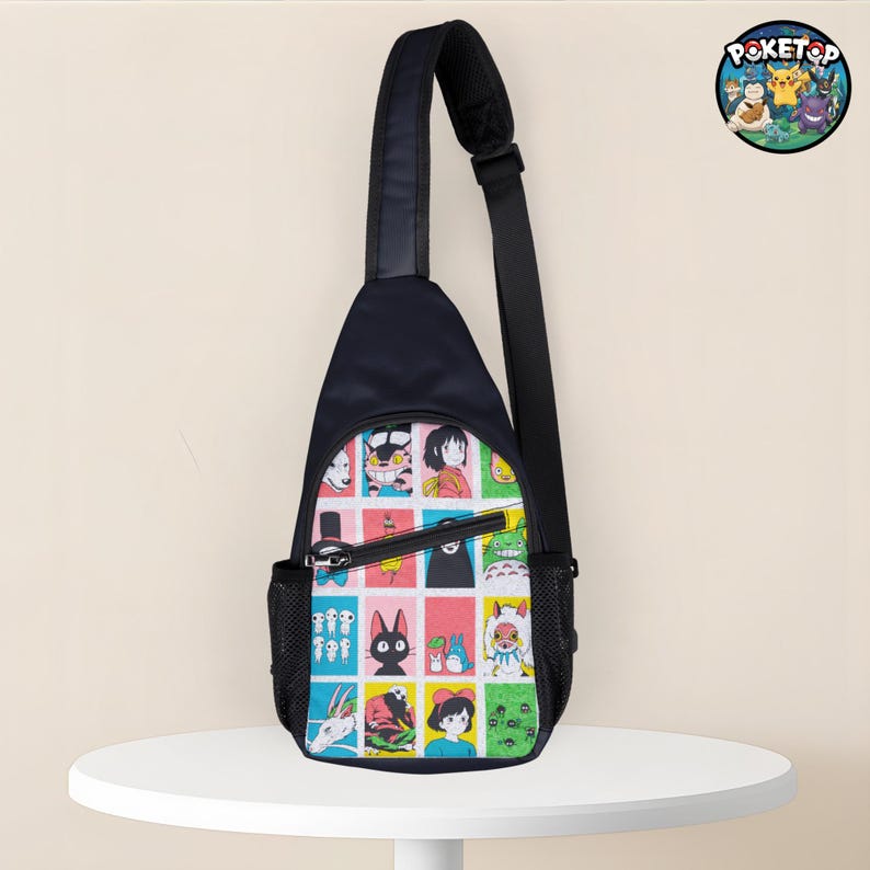 May include: A black sling bag with a colorful patchwork design featuring anime characters. The bag has a single adjustable strap, a zippered main compartment, and a small mesh side pocket. A circular logo with cartoon characters is visible.
