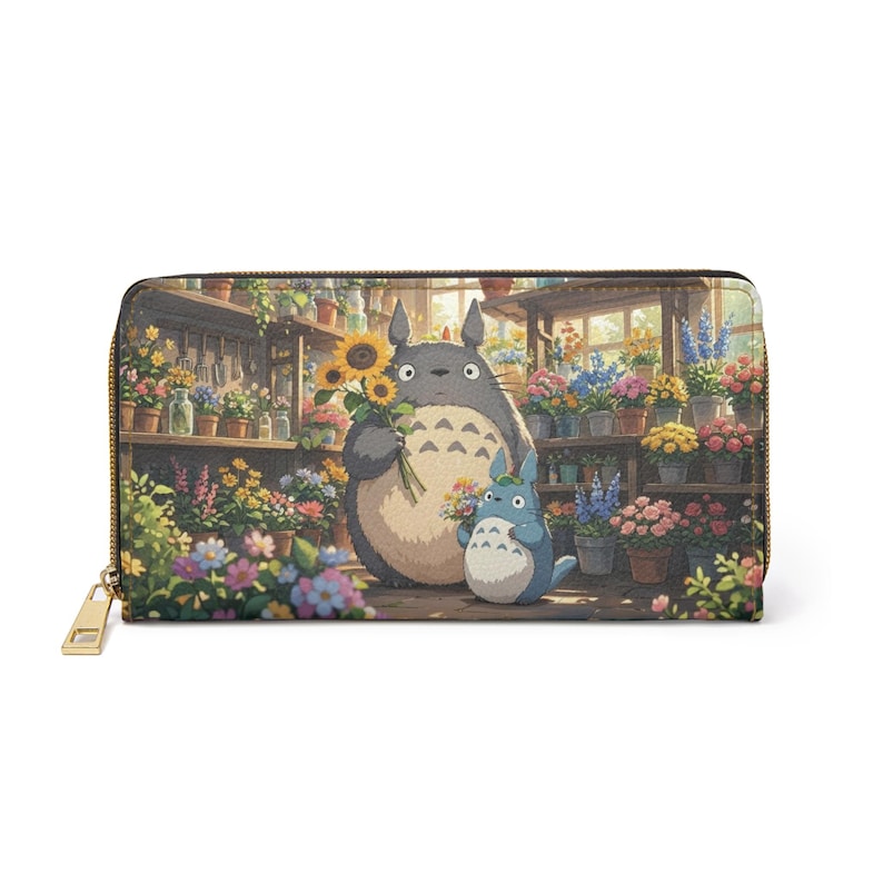 May include: A zip-around wallet with a colourful illustration of two cartoon characters in a flower shop, holding flowers. The wallet has a gold zip and a light-coloured interior. The background shows shelves filled with potted flowers.