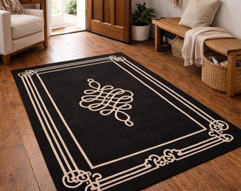May include: A rectangular black rug with a cream-colored border and a central decorative design. The rug is placed on a hardwood floor in a well-lit entryway. The rug's dimensions are not visible.