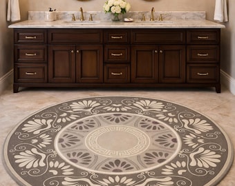 May include: A round, gray and cream-colored rug with a floral design in a bathroom setting. The rug features a central medallion with a Greek key pattern and is surrounded by stylized floral motifs. The bathroom has a dark wood vanity, oval mirrors, and sconces.