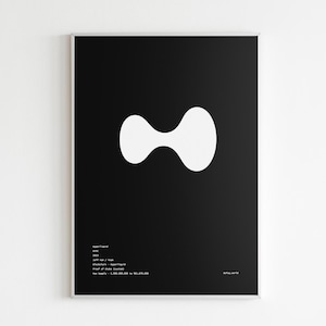 May include: A framed art print featuring a black background with a white, abstract, hourglass-like shape in the center. The bottom left corner contains white text. The print is displayed on a white wall.