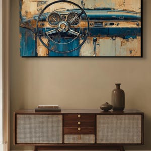 May include: An abstract painting of a classic car dashboard. The artwork features a black steering wheel, chrome gauges, and a blue and beige colour palette. The painting is displayed above a wooden cabinet with woven panels.
