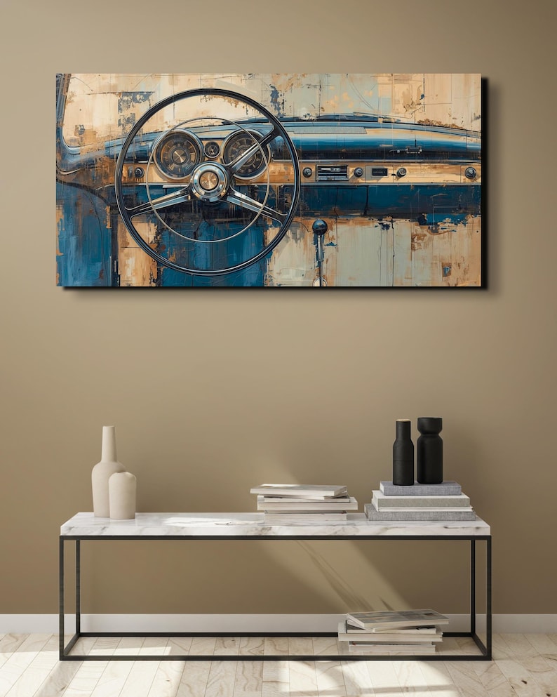 May include: An abstract painting of a classic car dashboard. The artwork features a black steering wheel, gauges, and a blue and beige colour palette. The painting is mounted on a wall above a marble-topped table.