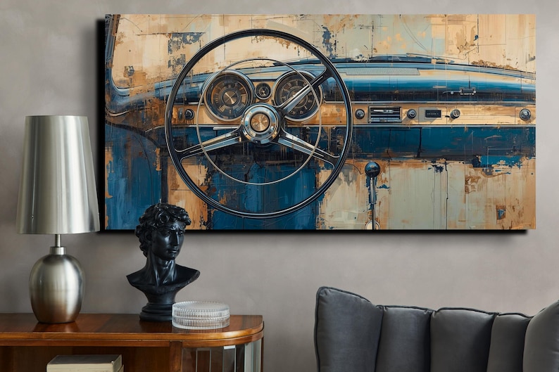 May include: Abstract art print of a classic car dashboard. The artwork features a steering wheel, gauges, and a blue and tan colour palette. The painting is displayed on a wall above a wooden table with a lamp and a bust.