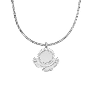 May include: A silver-colored necklace featuring a pendant with a sun design and two stylized wings. The pendant hangs from a chain with a textured, woven appearance. The necklace is displayed against a white background.