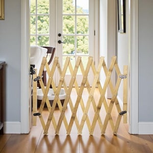 Op de afbeelding: Een uitbreidbaar hek van natuurlijk bamboe, geïnstalleerd in een deuropening. Het hek heeft een ruitpatroon en is bevestigd met zwarte en zilveren hardware. Het hek is gemaakt van lichtbruin bamboe en staat op een hardhouten vloer.