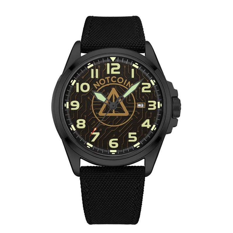 May include: Black wristwatch with a black fabric band. The watch face features the word "NOTCOIN" above a gold triangle logo. The numbers and hands glow in a light green color. The watch has a date display at the 3 o'clock position.