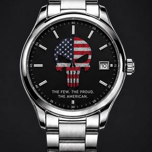 以下が含まれることがあります： 黒い文字盤にアメリカ国旗を組み合わせたスカルデザインが特徴のステンレススチール製腕時計。「THE FEW. THE PROUD. THE AMERICAN.」の文字が文字盤にプリントされています。3時の位置に日付表示があります。