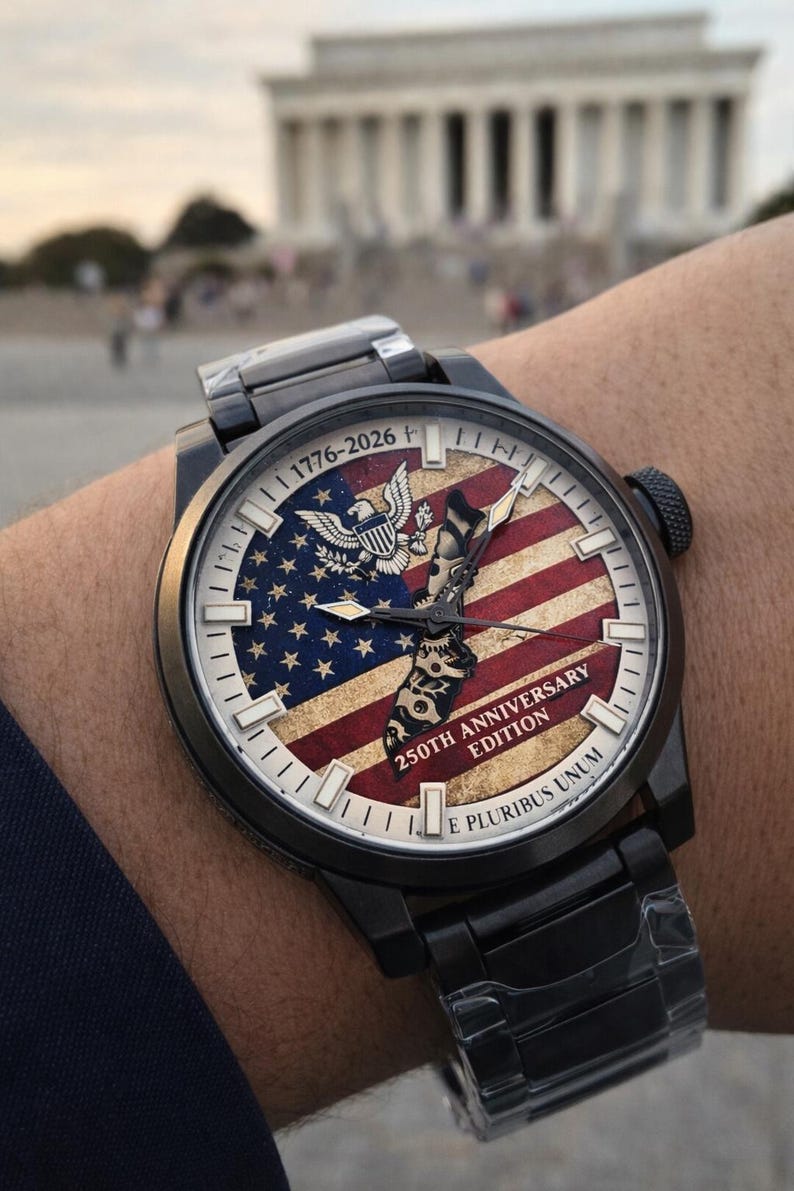 K&ouml;nnte beinhalten: Schwarze Armbanduhr mit patriotischem Design. Das Zifferblatt zeigt die amerikanische Flagge, einen Adler und den Text "1776-2026 250th Anniversary Edition E Pluribus Unum." Die Uhr hat ein schwarzes Metallarmband.