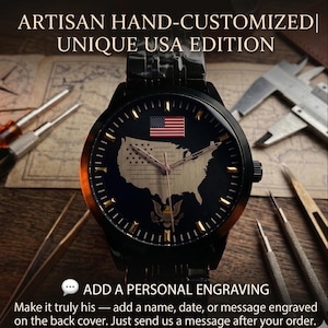 Puede incluir: Reloj de pulsera negro con esfera azul oscuro con un mapa dorado de los Estados Unidos y una pequeña bandera estadounidense. El reloj tiene marcadores de hora dorados y el texto "ARTISAN HAND-CUSTOMIZED | UNIQUE USA EDITION".