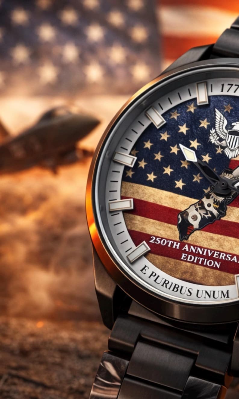 K&ouml;nnte beinhalten: Eine Armbanduhr mit einem dunklen Metallarmband und einem Zifferblatt mit dem Design der amerikanischen Flagge. Das Zifferblatt enth&auml;lt den Text "250th Anniversary Edition" und "E Pluribus Unum". Der Hintergrund zeigt ein verschwommenes Bild eines Jets.