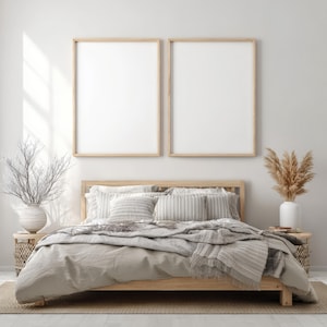 May include: A cozy bedroom scene featuring a wooden bed frame with neutral-toned bedding and pillows. Two framed blank art prints hang above the bed. Decorative elements include vases with dried plants and woven side tables, creating a serene, minimalist aesthetic.