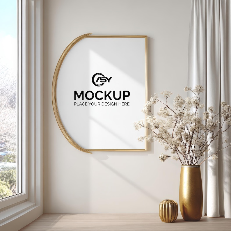 May include: A gold-framed picture frame with a white interior, displaying the word "MOCKUP" in black text. A gold vase with white flowers and a small gold decorative object are on a wooden surface.