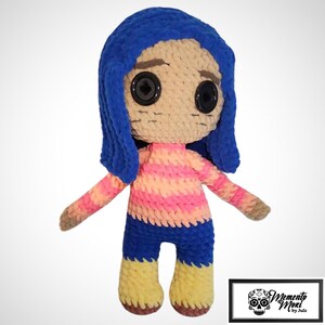 May include: A handmade crochet doll with blue hair, large black button eyes, and a striped pink and peach shirt. The doll has blue shorts and yellow shoes. The doll's arms are outstretched. The doll is a character from a movie.