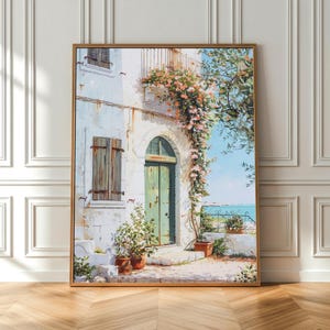 Peut inclure: Peinture encadrée représentant une scène méditerranéenne. Un bâtiment blanc avec une porte et des volets verts est orné de fleurs grimpantes. L'œuvre présente un balcon, des plantes en pot et une vue sur la mer, le tout dans un cadre en bois.