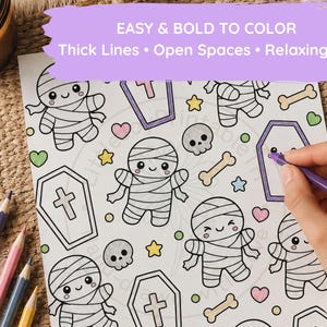 Pu&ograve; includere: Una pagina da colorare con un motivo ripetuto di mummie, bare, teschi, ossa e cuori in stile cartone animato. Il testo in alto recita EASY & BOLD TO COLOR Thick Lines &bull; Open Spaces &bull; Relaxing Fun. Matite colorate sono visibili di lato.