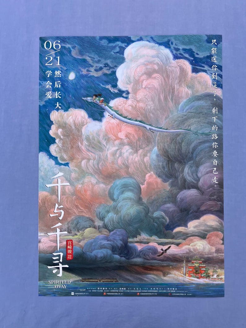 Puede incluir: P&oacute;ster de la pel&iacute;cula de animaci&oacute;n "El Viaje de Chihiro" con una escena fant&aacute;stica de una criatura parecida a un drag&oacute;n volando entre nubes coloridas. El texto incluye el t&iacute;tulo de la pel&iacute;cula en caracteres japoneses y el texto en ingl&eacute;s "SPIRITED AWAY".