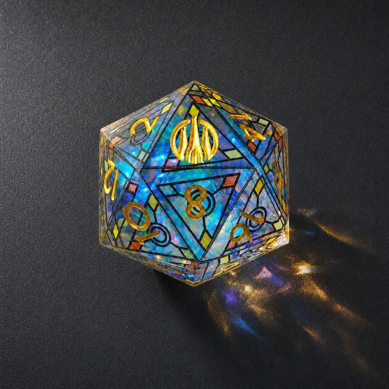 May include: A twenty-sided die featuring a stained glass pattern with iridescent blue and purple hues. The die has gold-colored numbers and a gold emblem at the top. The surface reflects light, casting colorful patterns onto the surrounding area.
