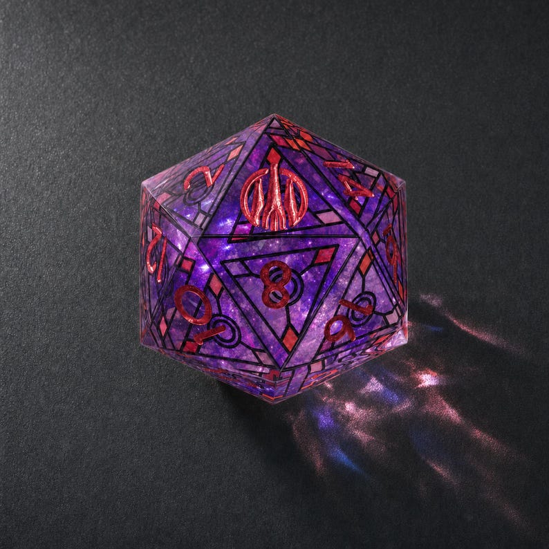 May include: A twenty-sided die featuring a translucent purple and blue galaxy-like interior. The surface is decorated with black geometric stained-glass style lines and red numbering. A red trident symbol replaces the number twenty on the top face.