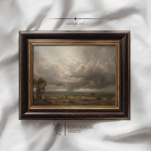 Peut inclure: Une impression d'art vintage encadrée représentant un paysage dramatique avec un ciel orageux et une averse de pluie lointaine. L'œuvre d'art présente un cadre marron foncé avec une bordure intérieure dorée. Le texte "vintage art" est en haut.