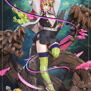 May include: A detailed figure of a female anime character in a dynamic pose, wielding a sword. She wears a black and white outfit with green and pink accents, and green knee-high socks. The figure is set against a backdrop of stylized tree-like structures.