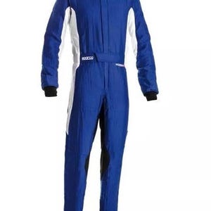 May include: A blue racing suit with white and black accents. The suit has a high collar, long sleeves, and a belt at the waist. The shoulders have white patches with black text. The suit is designed for motorsports.
