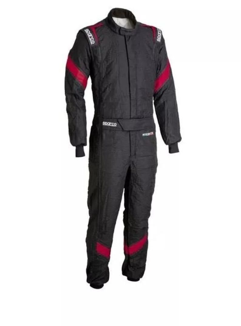 May include: Black racing suit with red accents on the shoulders, sleeves, and legs. The suit has a high collar and a front zipper. The brand name "Sparco" is visible on the shoulders and waist.