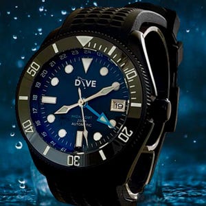 Op de afbeelding: Een zwart duikhorloge met een blauwe wijzerplaat, witte uurmarkeringen en wijzers. Het horloge heeft een zwarte lunette met witte cijfers en een zwarte rubberen band. De wijzerplaat toont het woord "DIVE" en de datum.