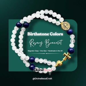 Puede incluir: Una pulsera de rosario con cuentas blancas y azules con una cruz y un cierre de medallón dorados. La pulsera presenta el texto "Birthstone Colors Rosary Bracelet" y "Divine Bead".