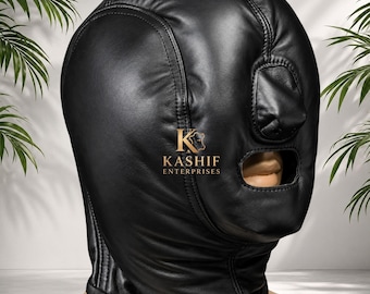May include: A black leather hood mask featuring a full-head design with stitched seams, a nose covering, and an open mouth area. The center of the mask displays the gold-colored text KASHIF ENTERPRISES with a small logo icon above the brand name.