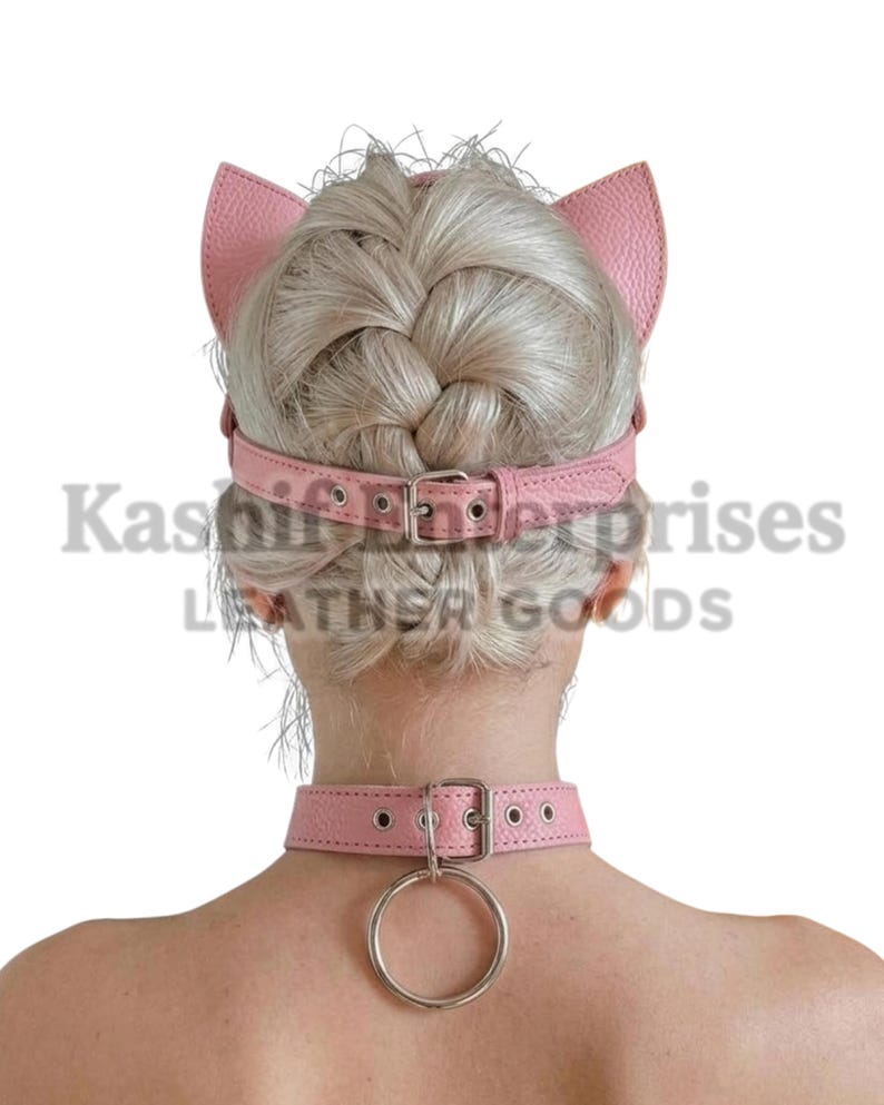 Puede incluir: Diadema de orejas de gato de cuero rosa y gargantilla a juego con un anillo de metal plateado. La diadema tiene correas ajustables y cierres de hebilla. La gargantilla tambi&eacute;n tiene cierre de hebilla y un anillo de metal.