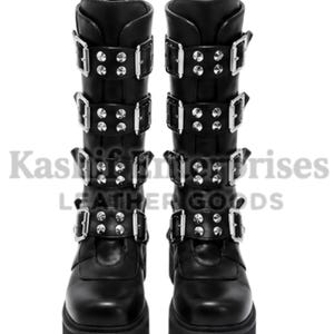 May include: A pair of black mid-calf boots featuring four horizontal straps with silver-toned metal buckles and circular studs on each boot. The boots have a thick platform sole and a rounded toe. The text Kashif Enterprises LEATHER GOODS is visible.