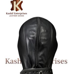 May include: Black leather hood with a full head and neck covering, featuring a vertical zipper and a buckled collar secured with a padlock. The logo "Kashif Enterprises LEATHER GOODS" is visible.