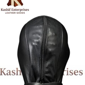 May include: Black leather hood with a full head and neck coverage. The hood features a vertical zipper down the front and a buckled strap around the neck. The product is from Kashif Enterprises Leather Goods.