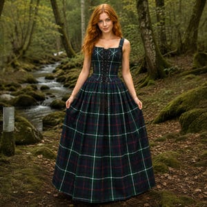 Puede incluir: Un vestido largo a cuadros en tonos verdes, azul marino y rojo. El vestido presenta un escote cuadrado, un corpiño con cordones y una falda amplia. La modelo está en un entorno forestal, con un arroyo al fondo. El vestido es un diseño clásico y atemporal.