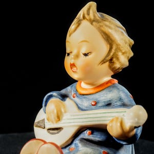 Statuetta vintage Goebel raffigurante un bambino che suona il mandolino, in ceramica tedesca.