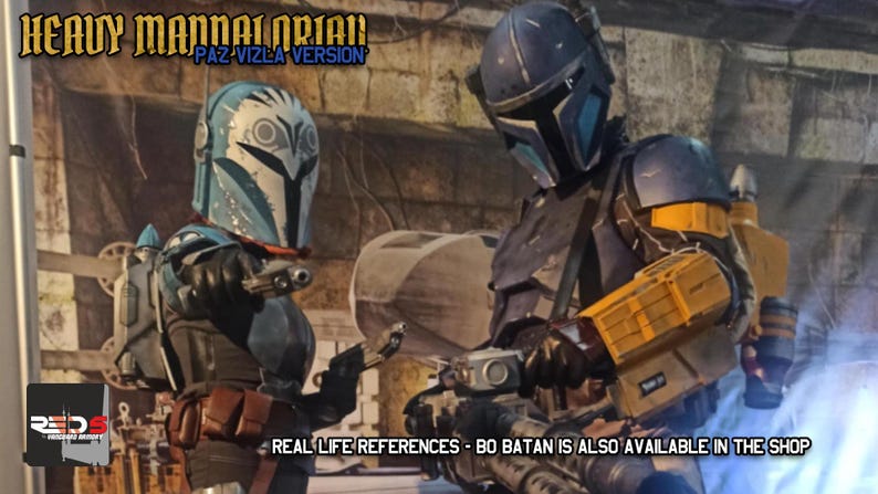 Puede incluir: Dos trajes de armadura completos con cascos y bl&aacute;steres. El traje izquierdo es azul y blanco con marcas de b&uacute;ho. El traje derecho es azul oscuro y amarillo con un bl&aacute;ster pesado. Texto: HEAVY MANDALORIAN PAZ VIZLA VERSION y REDS.