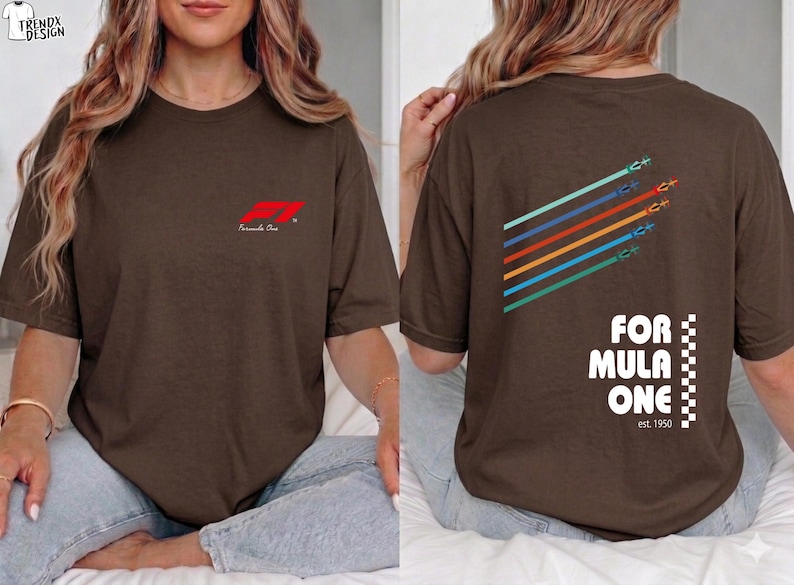 Pu&ograve; includere: Una t-shirt a maniche corte marrone scuro con un piccolo logo rosso Formula One sul petto. Il retro mostra una grafica con cinque linee diagonali colorate con icone di auto da corsa, il testo FORMULA ONE e la scritta est. 1950.