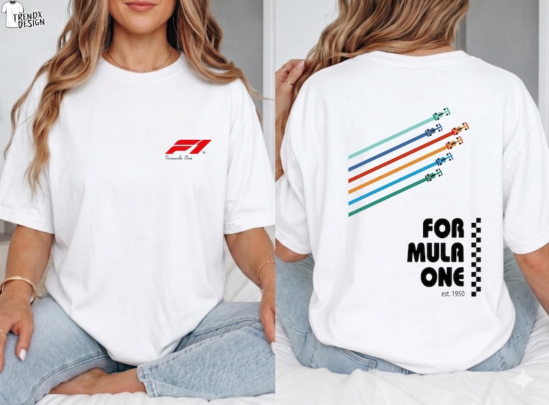 Pu&ograve; includere: Una t-shirt bianca con un piccolo logo rosso Formula One sul petto a sinistra. Il retro mostra una grafica di cinque auto da corsa colorate con linee di velocit&agrave; diagonali, il testo "FORMULA ONE" in nero e un motivo a scacchi verticale.