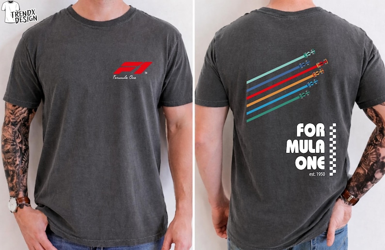 Pu&ograve; includere: Una t-shirt grigio antracite a maniche corte con un piccolo logo rosso Formula One sul petto. Il retro mostra una grafica di sei auto da corsa colorate con linee di velocit&agrave; diagonali e il testo Formula One est. 1950 con un bordo a scacchi.