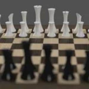 May include: A chessboard with black and white chess pieces. The white pieces are in focus, showing a rook, queen, and pawns. The black pieces are blurred in the foreground. The board has a brown and beige checkered pattern.