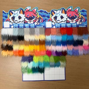Può includere: Esposizione di campioni di finta pelliccia in vari colori, tra cui marrone, nero, arancione, giallo, verde, blu, viola e rosa. Ogni campione è disposto in un motivo a griglia, con un'illustrazione di un gatto e il testo "fur moon".