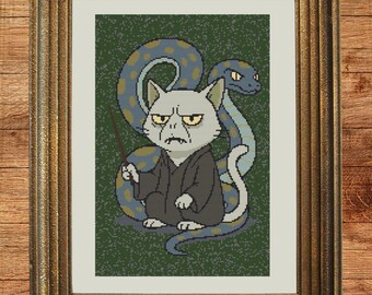 May include: Cross-stitch art print in a gold frame. The image features a cat dressed in a dark robe, holding a wand, with a snake behind it. The background is green. The text "Instant Download PDF" is in the bottom right corner.