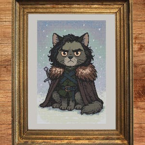 May include: Cross-stitch pattern of a cat dressed as a character from a fantasy series, wearing a fur-lined cloak and holding a sword. The cat has dark fur and a stern expression. The image is in a gold frame with the text "Instant Download PDF".