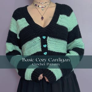 May include: A crochet cardigan with horizontal stripes in black and mint green. The V-neck cardigan has three heart-shaped buttons. The text "Basic Cozy Cardigan Crochet Pattern" is displayed on the bottom of the image.