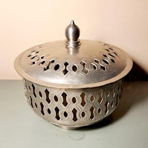 Könnte beinhalten: Ein Set aus drei Keramikbechern mit gesprenkelter, matter Oberfläche. Die Becher sind in Creme-, Hellgrau- und Dunkelgrautönen gehalten. Jeder Becher hat ein schlichtes, minimalistisches Design, perfekt für Kaffee oder Tee.