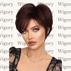 May include: A woman with blue eyes and a short, dark red wig. The wig has a side-swept bang and is styled in a layered pixie cut. She is wearing a gold necklace and a black lace top. The background has the word "Wigory" repeated.