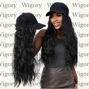 Peut inclure: Deux casquettes de baseball noires avec de longues extensions de cheveux noirs et ondulés. Une casquette est tenue, mettant en valeur la texture des cheveux. L'autre casquette est portée par une personne. Le fond porte le mot "Wigory".